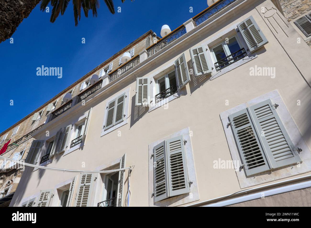 Straßenblick auf die oberen Etagen von Wohngebäuden mit malerischen Fenstern in der Altstadt von Split, Kroatien. Stockfoto