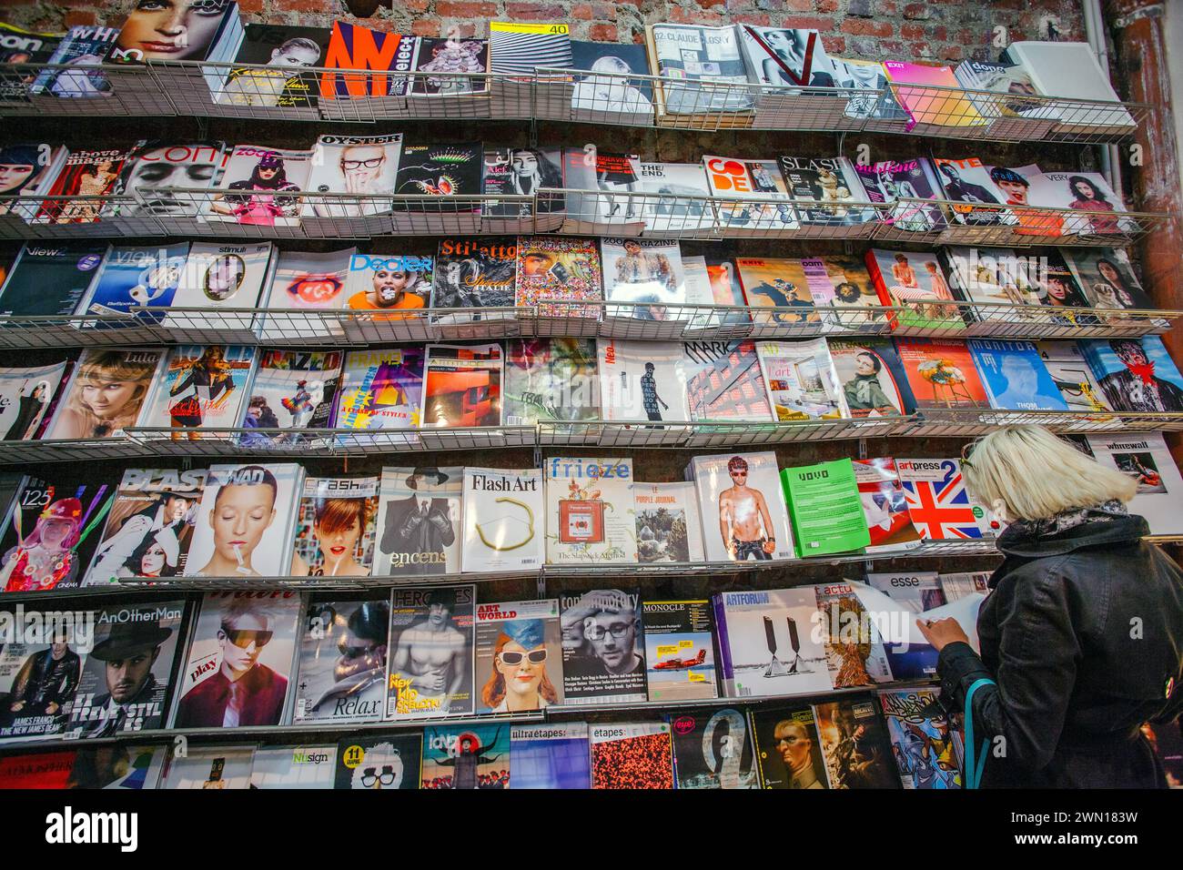 Frau liest Zeitschriften in einem Geschäft Stockfoto