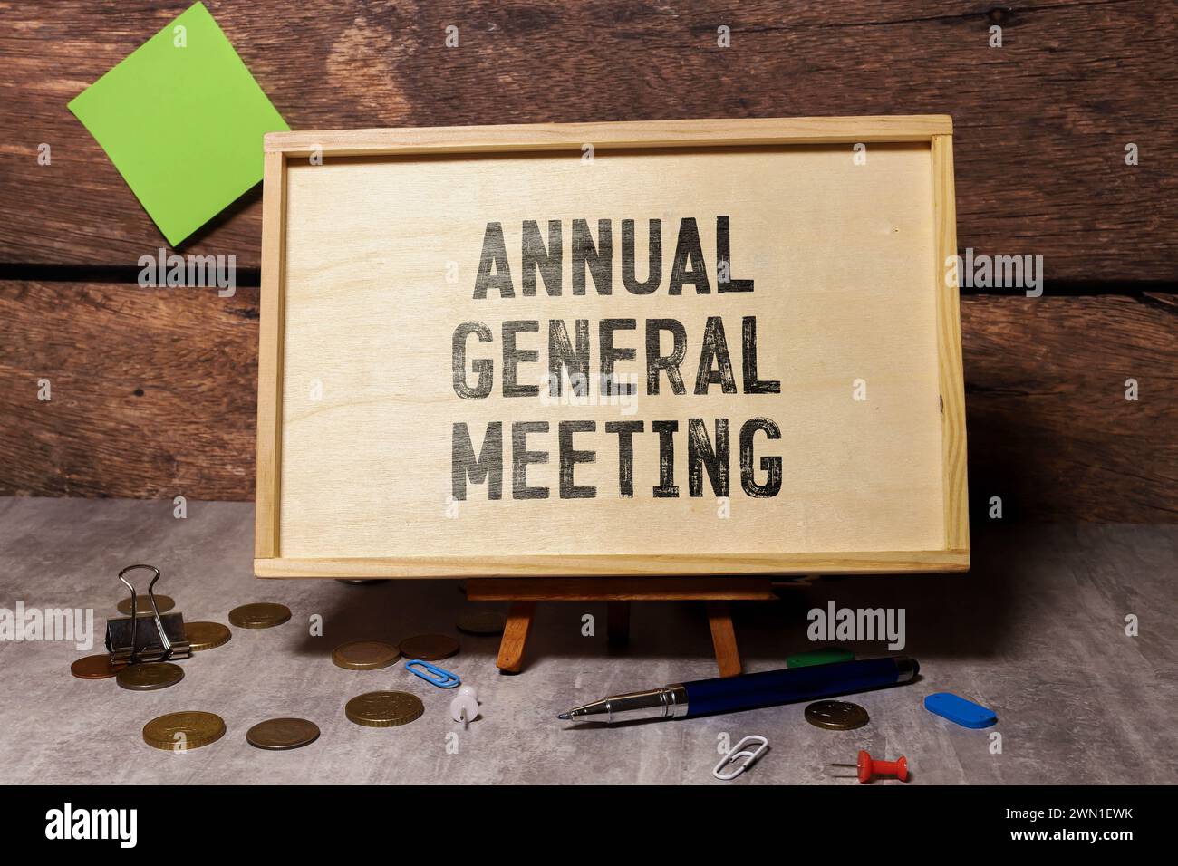 Auf hellem Hintergrund ein weißes Notizbuch mit den Worten AGM Annual General Meeting und einem Stift Stockfoto