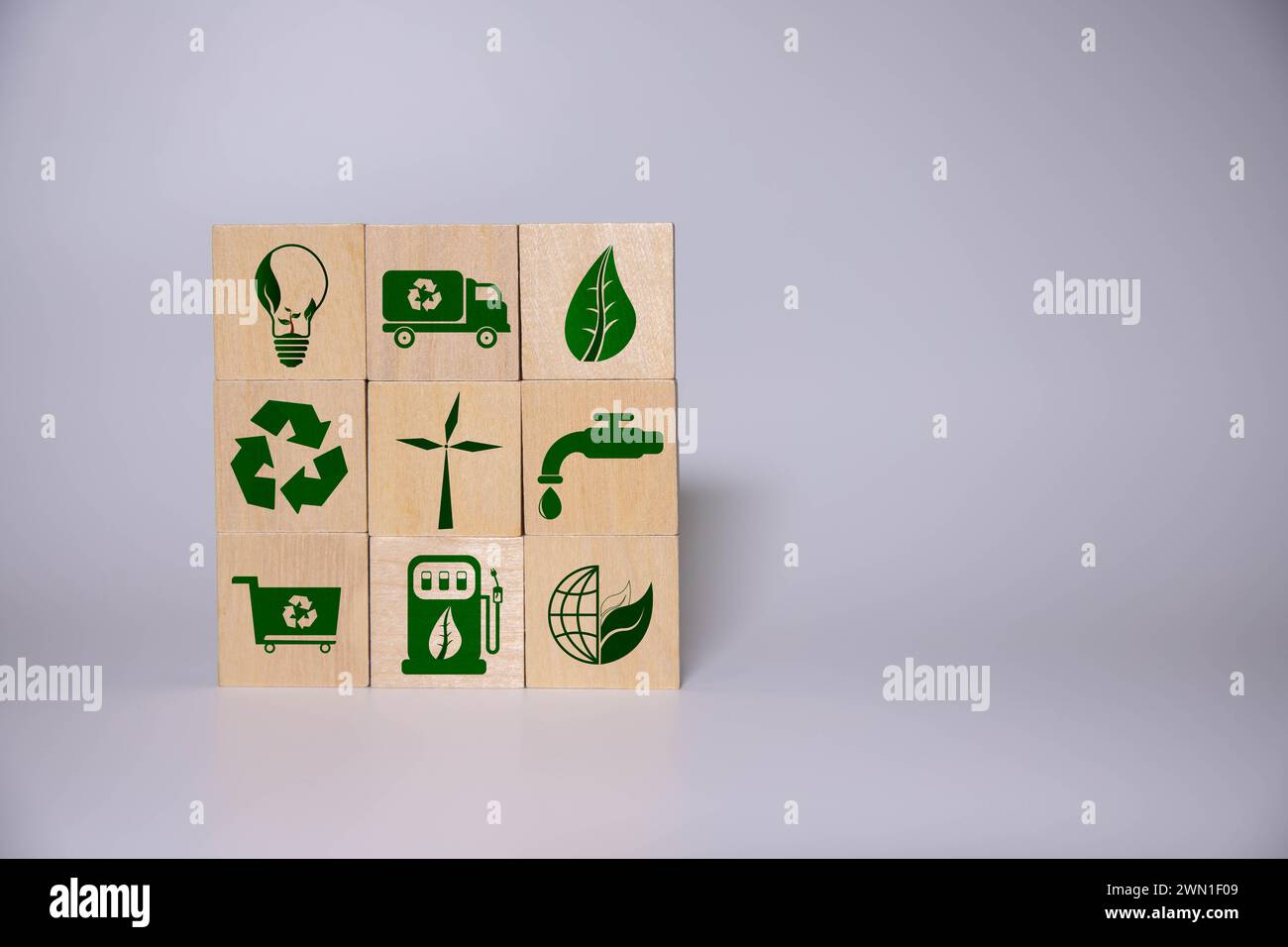Die grünen Holzblöcke auf dem Laptop mit Symbolen und Texten " Reduzieren, Wiederverwenden und recyceln ". Es geht um das Konzept der Verringerung des Elektronikschrott, Stockfoto