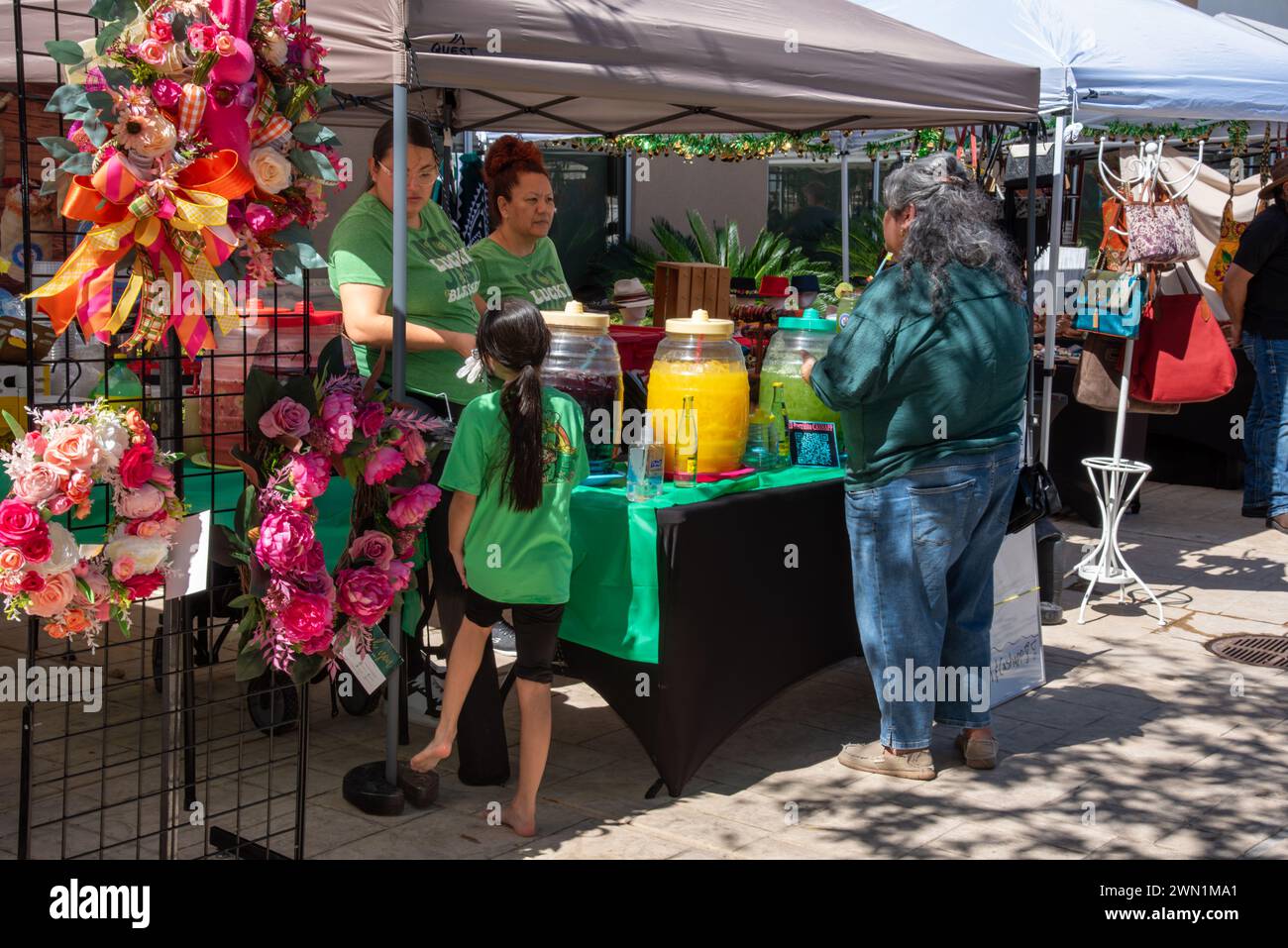 Kunde bei El Barrillito, zwei Mitarbeiter im Verkaufsstand, der frische Getränke beim South Texas Irish fest 2024 in McAllen, Hidalgo County, Texas, USA verkauft. Stockfoto