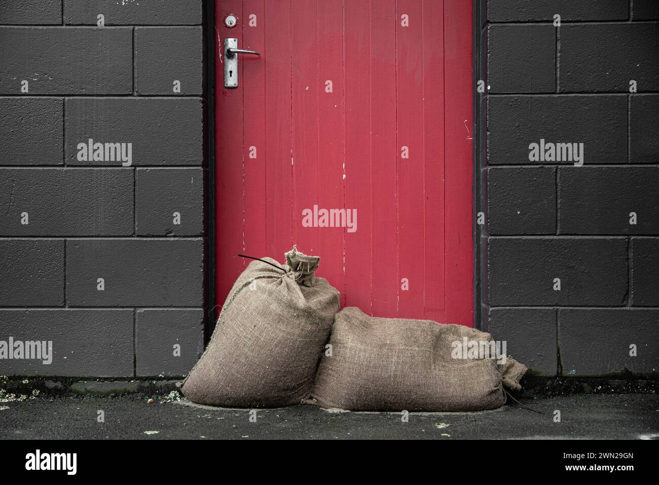 Nach dem Sturm - Sandsäcke gegen die Tür, um die Geschäfte vor der Naturkatastrophen-Wetterbombe, die Zyklon Gabrielle 2023 war, trocken zu halten. Stockfoto