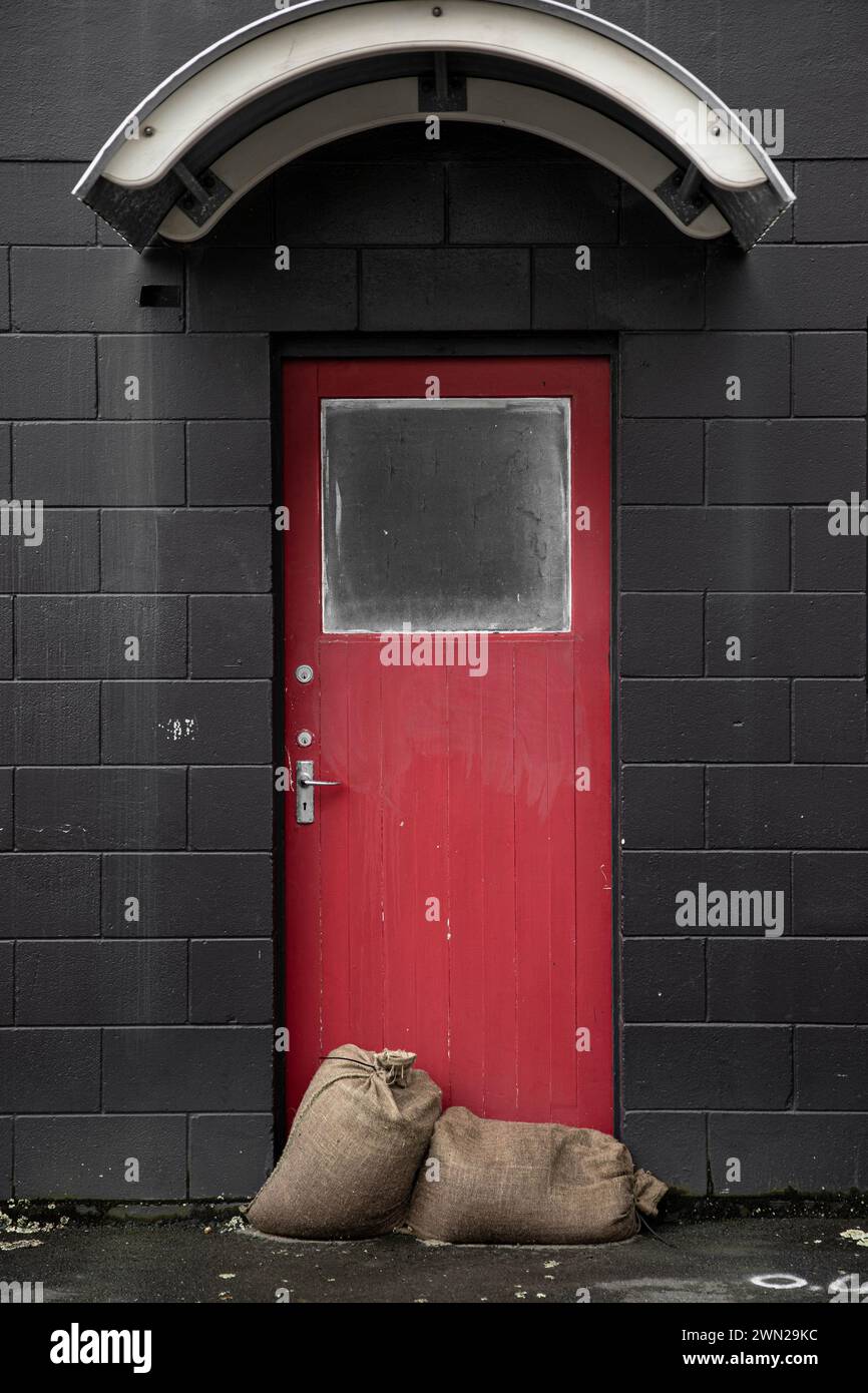 Nach dem Sturm - Sandsäcke gegen die Tür, um die Geschäfte vor der Naturkatastrophen-Wetterbombe, die Zyklon Gabrielle 2023 war, trocken zu halten. Stockfoto