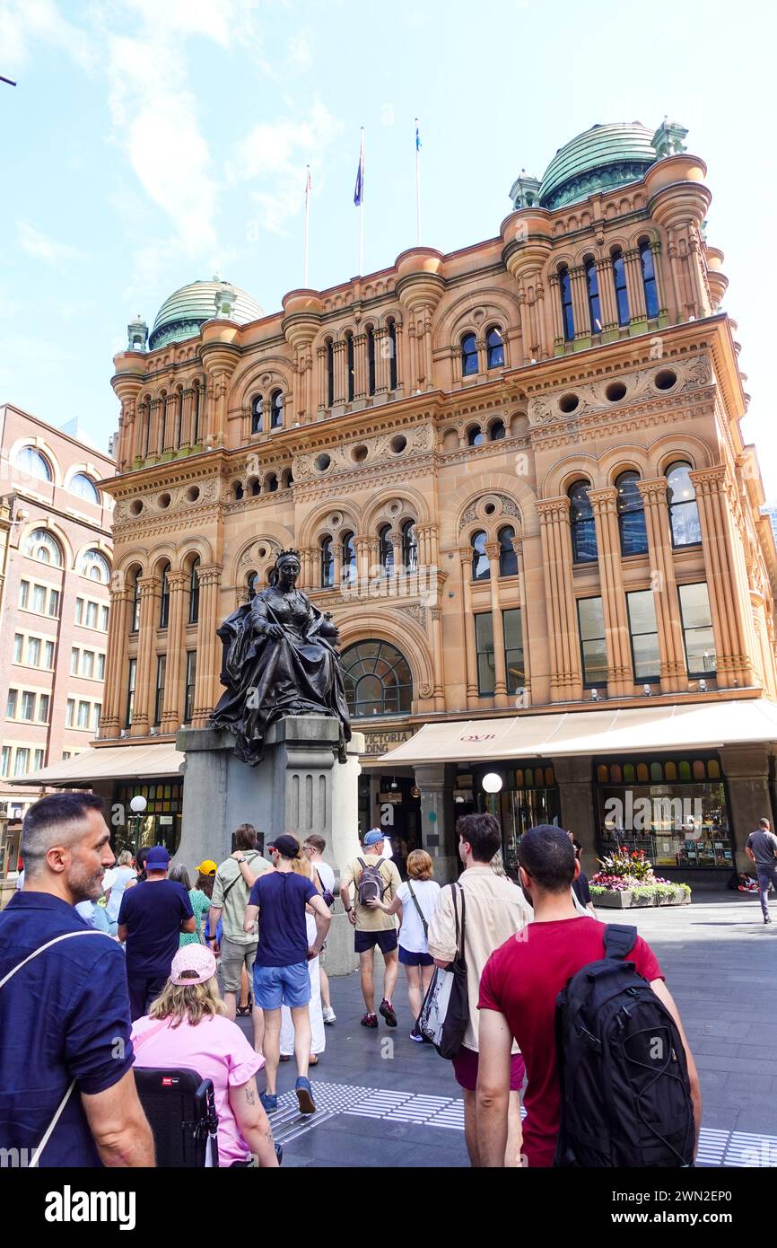 Eine Gruppe von Touristen, die zum Queen Victoria Building in Sydney, Australien, laufen, einem historischen und ikonischen Wahrzeichen, das für seine architektonische Schönheit bekannt ist Stockfoto