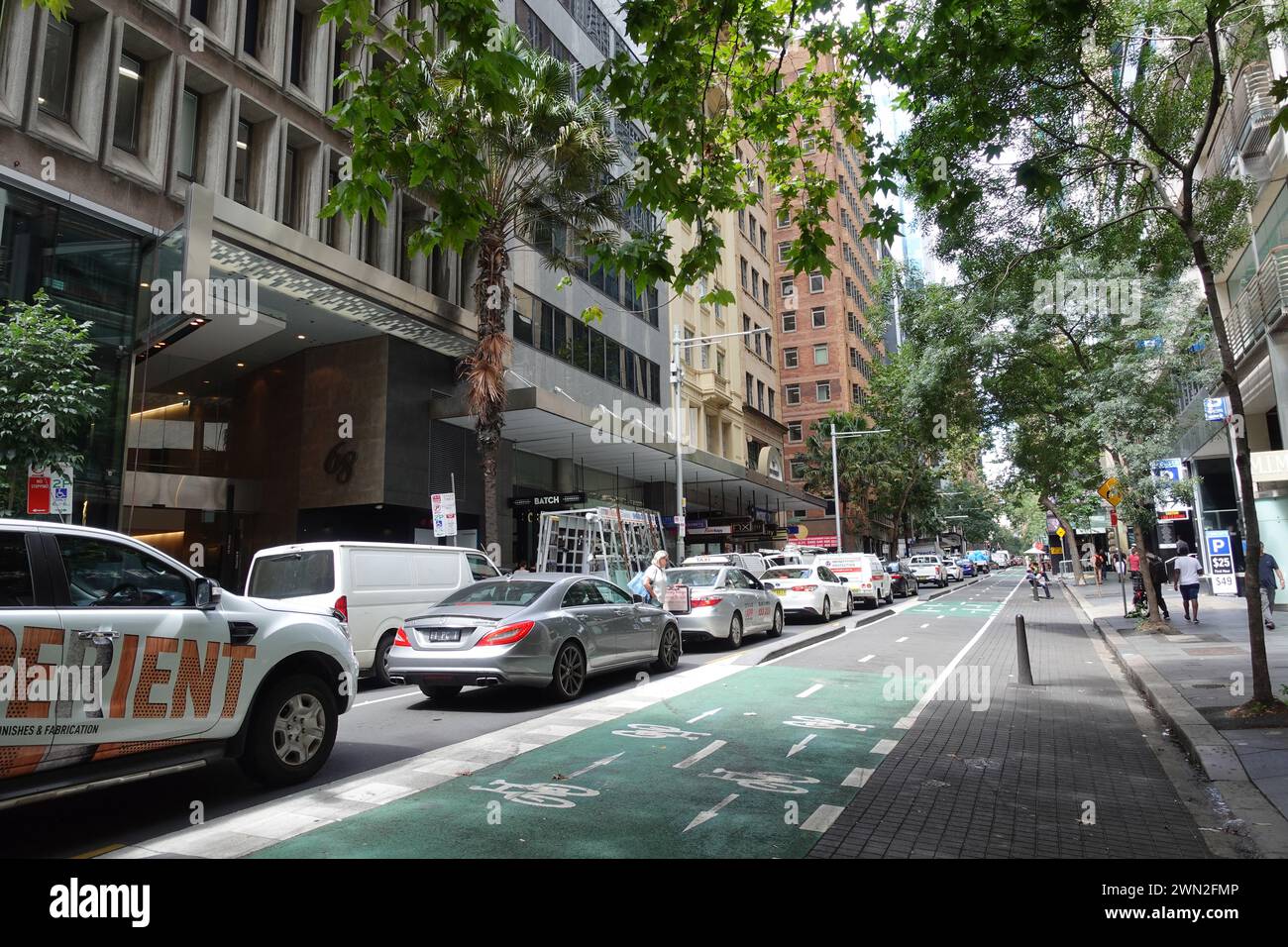 Im CBD von Sydney ist eine befahrene Straße mit Autos gesäumt, während die angrenzenden Radwege auffallend leer bleiben, was den anhaltenden Verkehr der Stadt unterstreicht Stockfoto