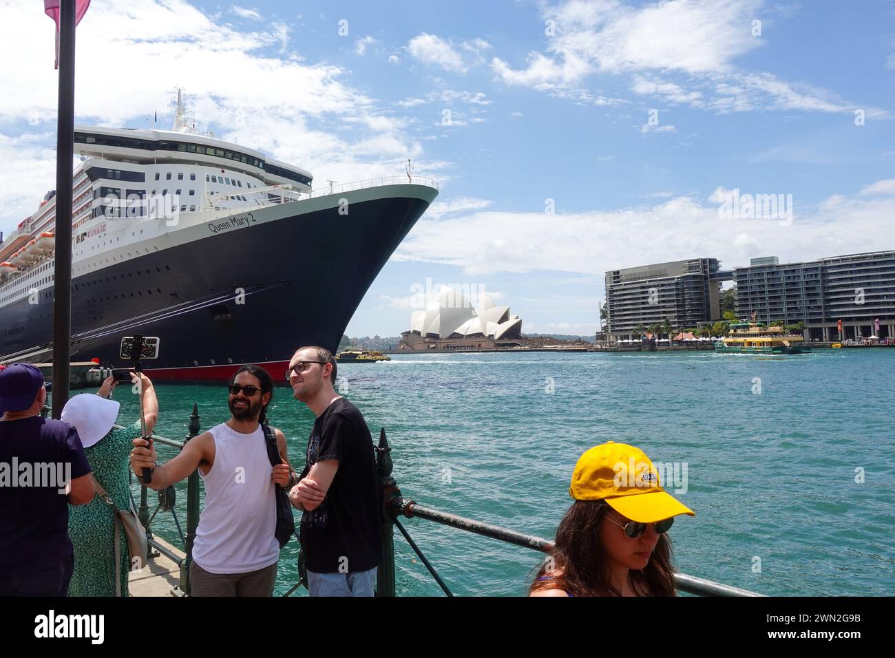 Touristen machen Selfies oder Fotos vor dem Opernhaus von Sydney, gegenüber vom Hafen von Sydney Stockfoto