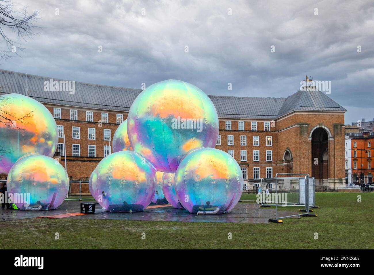 Eine große öffentliche Kunstinstallation mit mehreren großen, farbenfrohen schillernden Kugeln, die sich vor einem historischen Gebäude befinden. bristol großbritannien Stockfoto