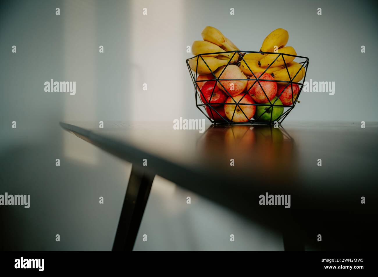 In einer Glasschale befindet sich eine Banane auf der Küchenzeile, die von warmem Tageslicht beleuchtet wird Stockfoto