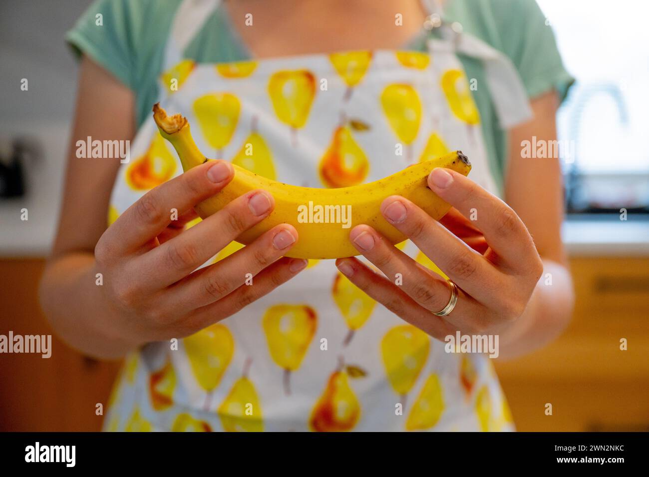 Frauenhände, die Bananen halten, natürliches Tageslicht Stockfoto
