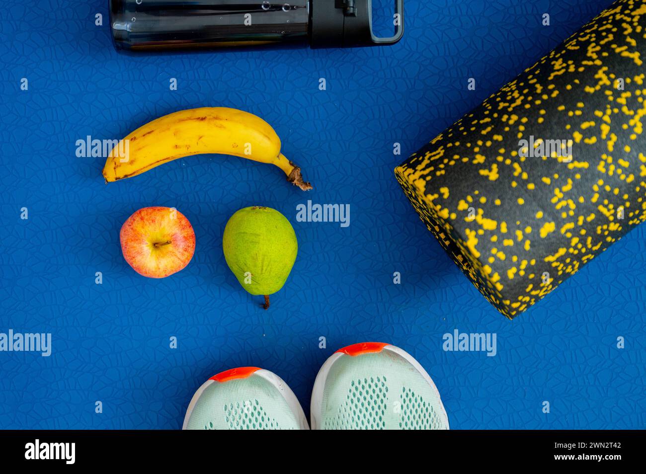 Bananen, Apfel, Birnen und Trainingsgeräte auf der Matte. Auftanken von Energie während des Trainings oder Workouts Stockfoto