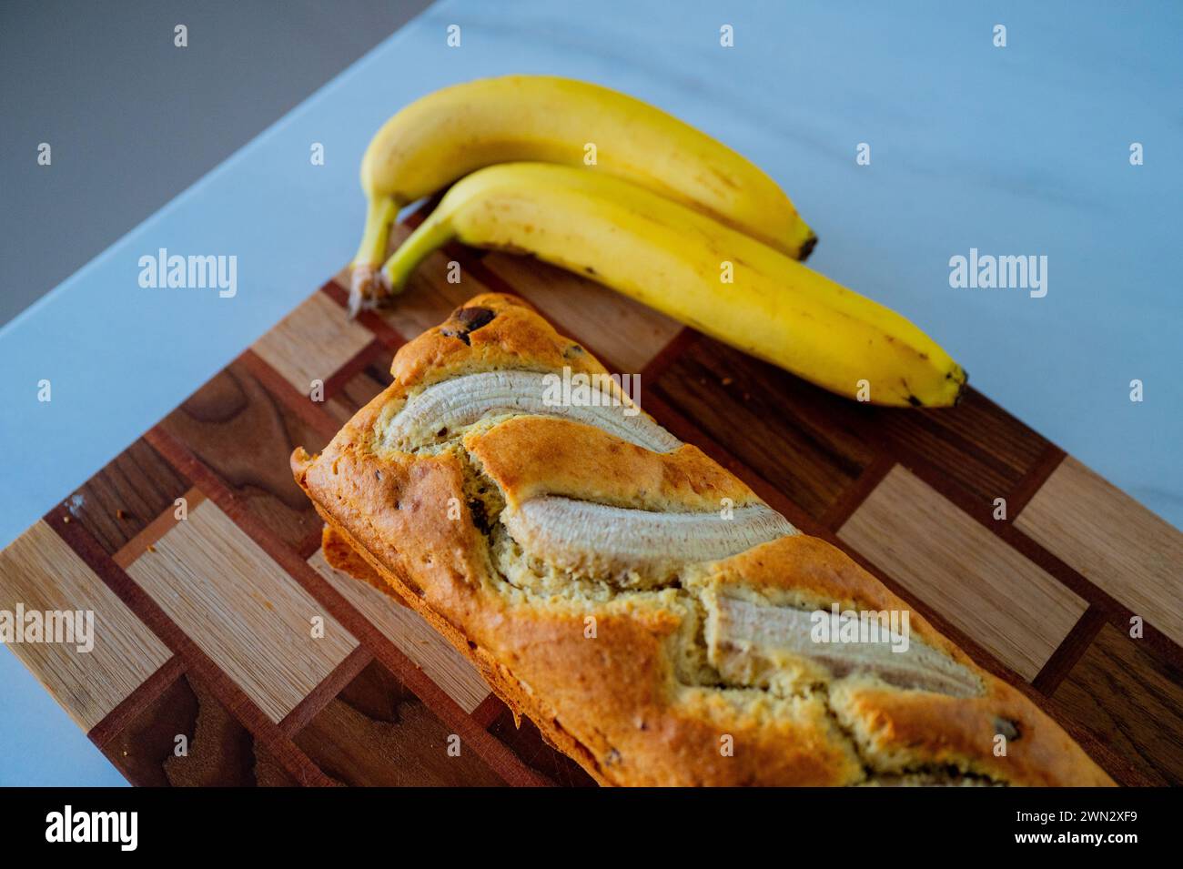 Auf der Küchenzeile: Bananenbrot und eine reife Banane bei Tageslicht Stockfoto