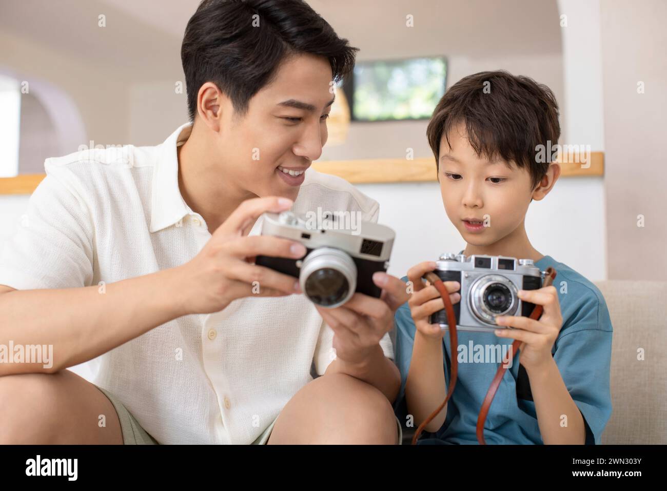 Glücklicher Vater und Sohn mit Kameras Stockfoto