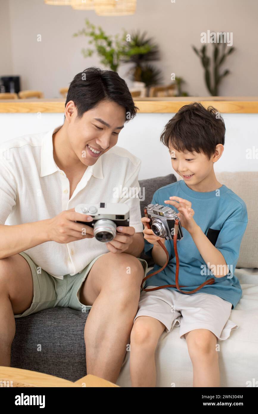 Glücklicher Vater und Sohn mit Kameras Stockfoto
