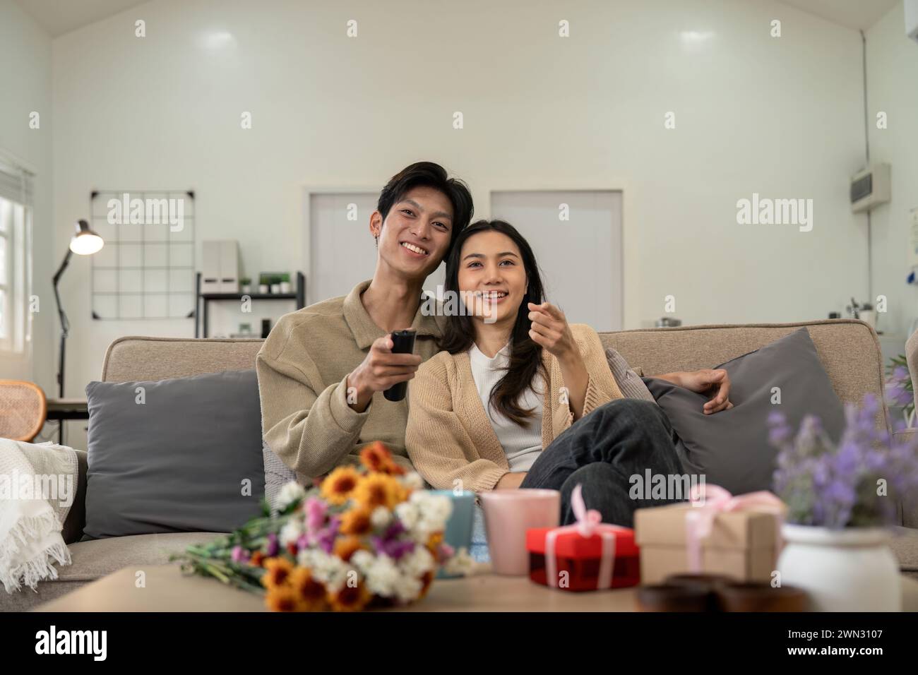 Asiatische Paare Lifestyle, Mann und Frau schauen TV-Film zu Hause, Familie Lifestyle Relax und Erholungskonzept. Verlieben Sie sich. Valentinstag-Konzept Stockfoto