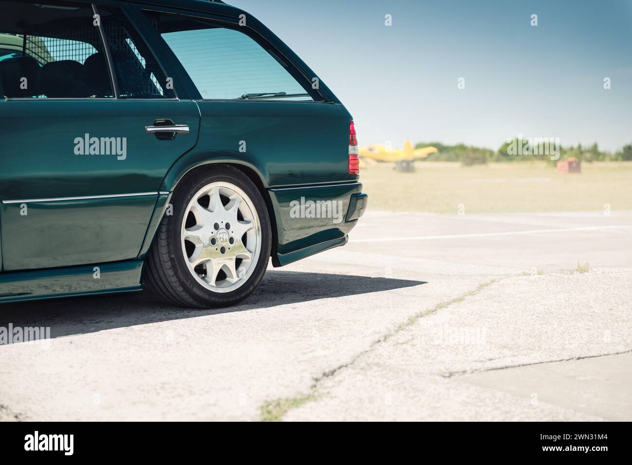 Hinteres Viertel des dunkelgrünen Mercedes Benz Wagens (Modell W124). Mercedes der 1980er-1990er Jahre mit BRABUS-Felgen an einem sonnigen Tag. Stockfoto