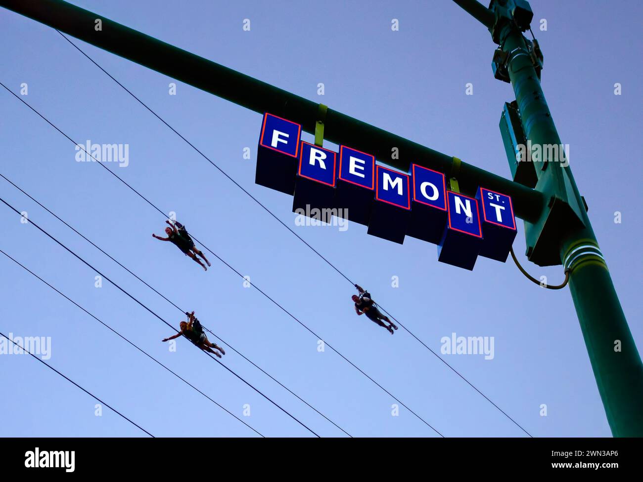 Menschen, die auf der Slotzilla Zipline auf der Fremont Experience in Las Vegas, Nevada, im Superhelden-Stil reiten Stockfoto