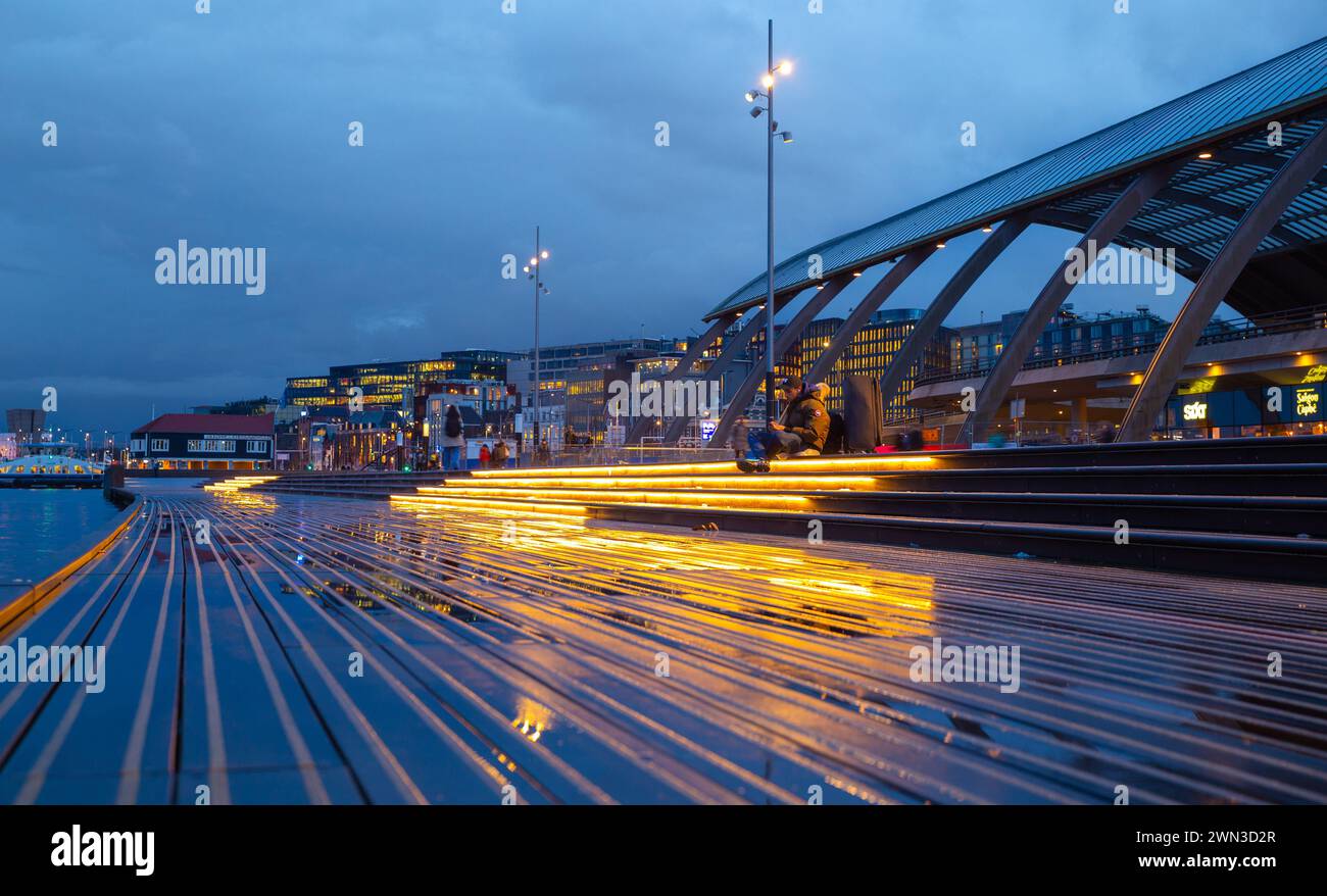 Amsterdam, Niederlande – 23. Februar 2024: Hauptbahnhof, Hafenblick mit Terrasse und Reflexion nach Regen Stockfoto