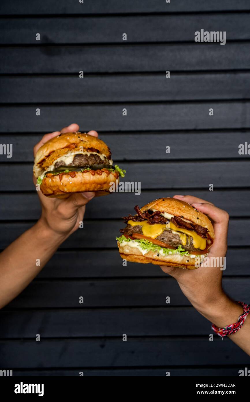 Zwei Freunde essen Cheeseburger vor einer Garage Stockfoto