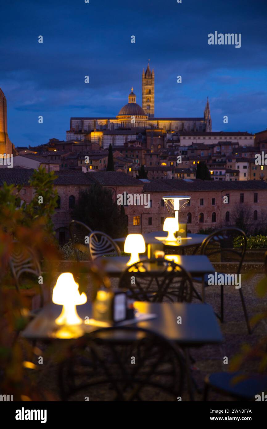Die Kaffeepunkte bei Nacht mit der Kathedrale von Siena im Hintergrund, Italien, gemütliche Urlaubsschwingung Stockfoto
