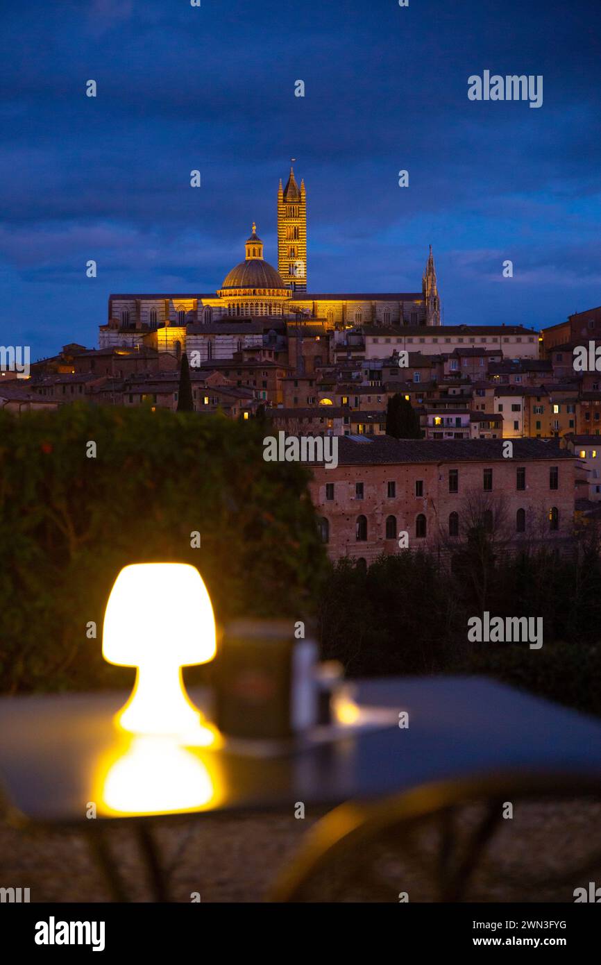 Die Kaffeepunkte bei Nacht mit der Kathedrale von Siena im Hintergrund, Italien, gemütliche Urlaubsschwingung Stockfoto