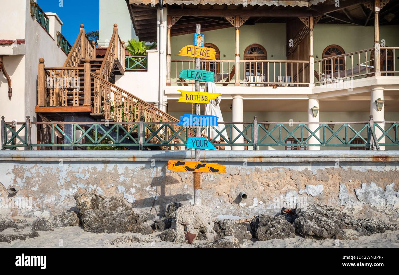 Ein Schild mit der Aufschrift „Bitte hinterlassen Sie nichts als Ihre Fußabdrücke“ am Strand in Stone Town, Sansibar, Tansania Stockfoto