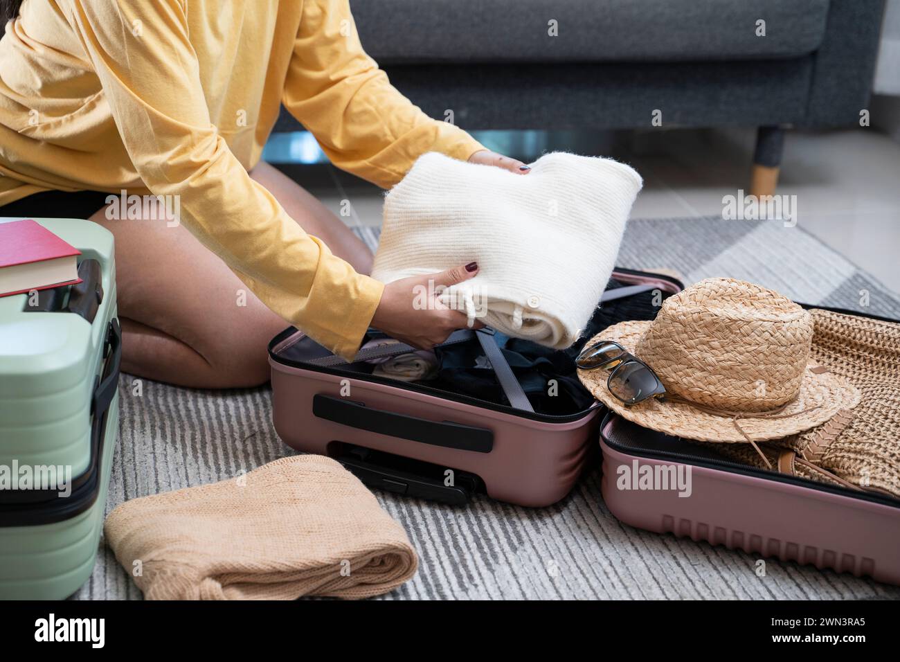 Junge Frauen, die sich auf den Urlaub vorbereiten. Reiseaccessoires. Reise- und Urlaubskonzept. Stockfoto