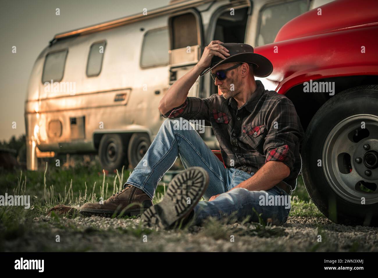 Amerikanischer Südwestkaukasischer Cowboy neben seinem klassischen Pickup-Truck und einem Trailer für Reisen Stockfoto