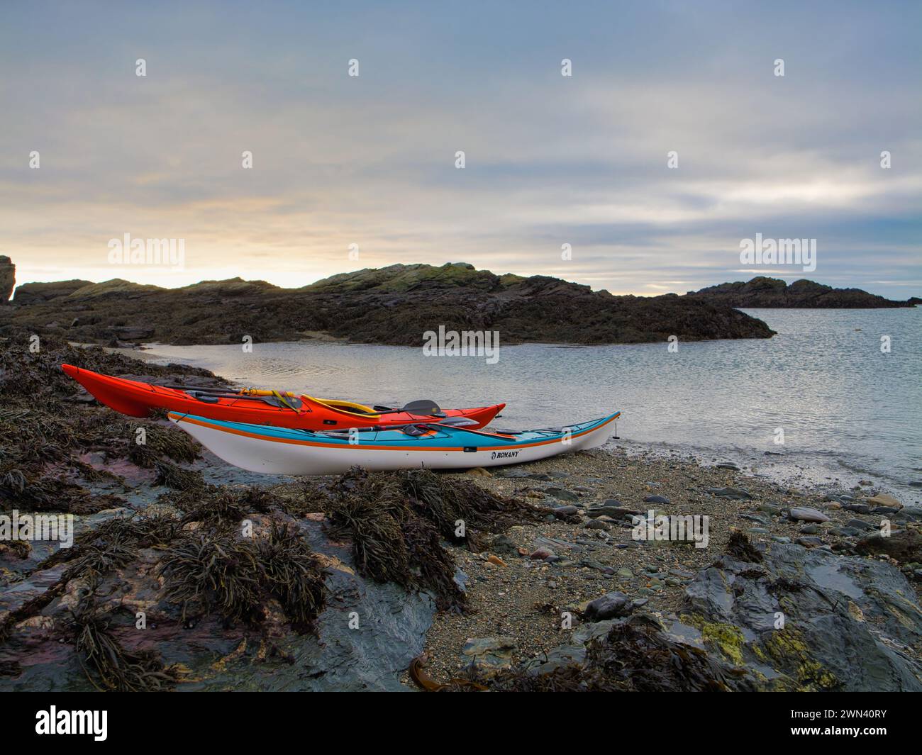 Anglesey, Vereinigtes Königreich - 11. Januar 2024: Zwei Seekajaks an einem einsamen Strand auf der Insel Anglesey in Nordwales, Vereinigtes Königreich. An einem ruhigen, bewölkten Tag im Winter. Stockfoto