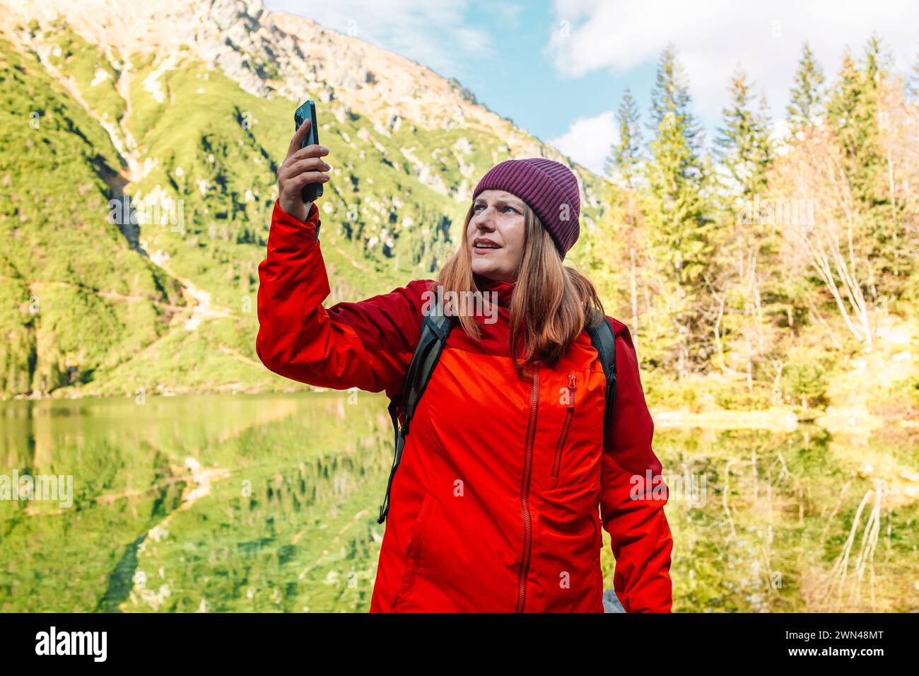 Verlorene Trekker-Reisende Frau aus den 30er Jahren, die mit dem Smartphone allein in einem Wald in der Nähe von Morskie Oko einen Ort sucht. Wanderer-Weibchen hat das Zellsignal verloren und Stockfoto