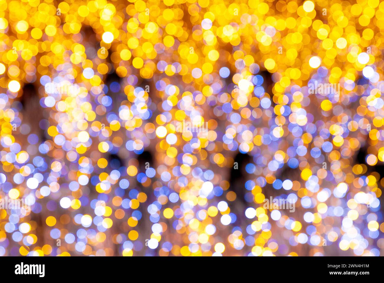 Glänzend goldenes Bokeh beleuchtet abstrakten festlichen Hintergrund mit glänzender Glitzerstruktur und heller glitzernder Beleuchtung Stockfoto