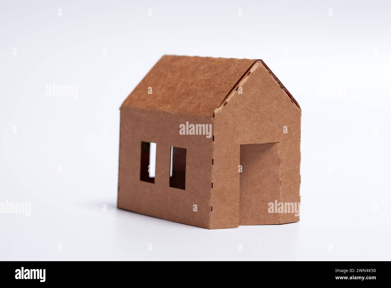 Einfaches Heimwerkerfamilienhaus - Pappmodell auf weißem Hintergrund Stockfoto