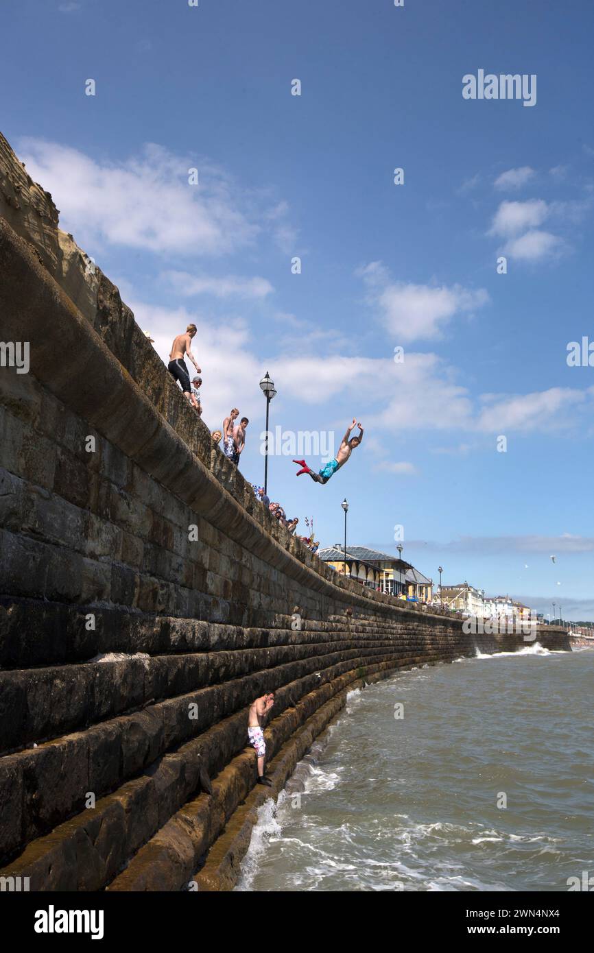 21/07/14 am ersten Montag der Schulferien werfen sich junge Jungs von der Meeresmauer in Bridlington ins Meer. Die Einheimischen schätzen sie Stockfoto