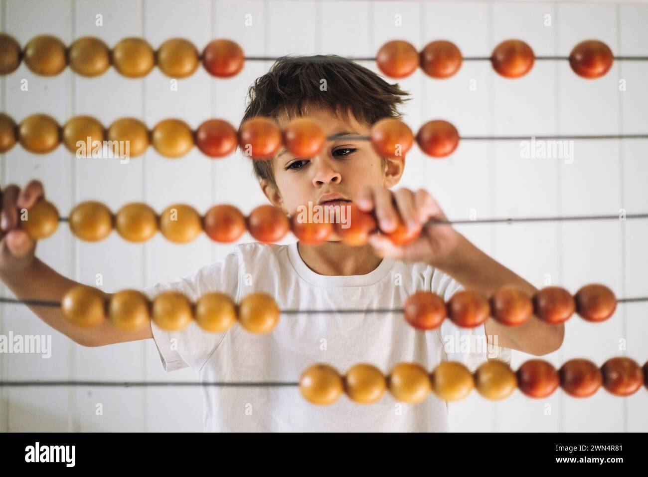 Junge, der mit Abacus zählt, im Kindergarten Stockfoto