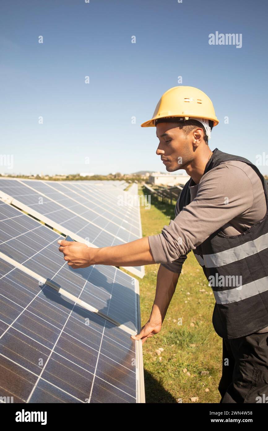 Junger männlicher Wartungstechniker fotografiert Solarpaneele durch Smartphone im Kraftwerk Stockfoto