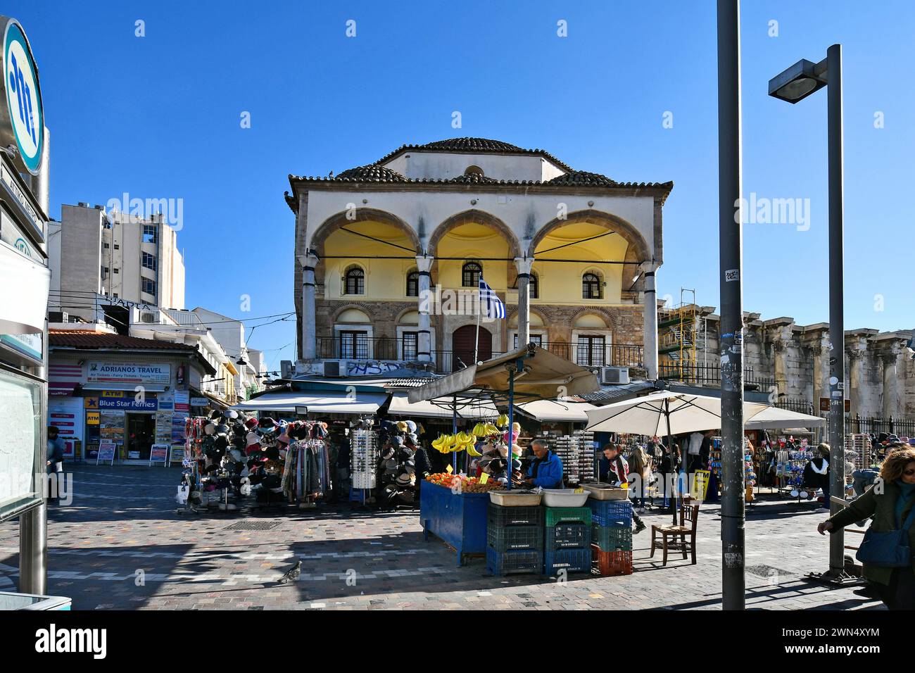 Athen, Griechenland - 19. Dezember 2023: Nicht identifizierte Menschen auf dem Monastiraki-Platz mit der Tzisdaraki-Moschee - heute als Museum für moderne griechische Kultur genutzt Stockfoto