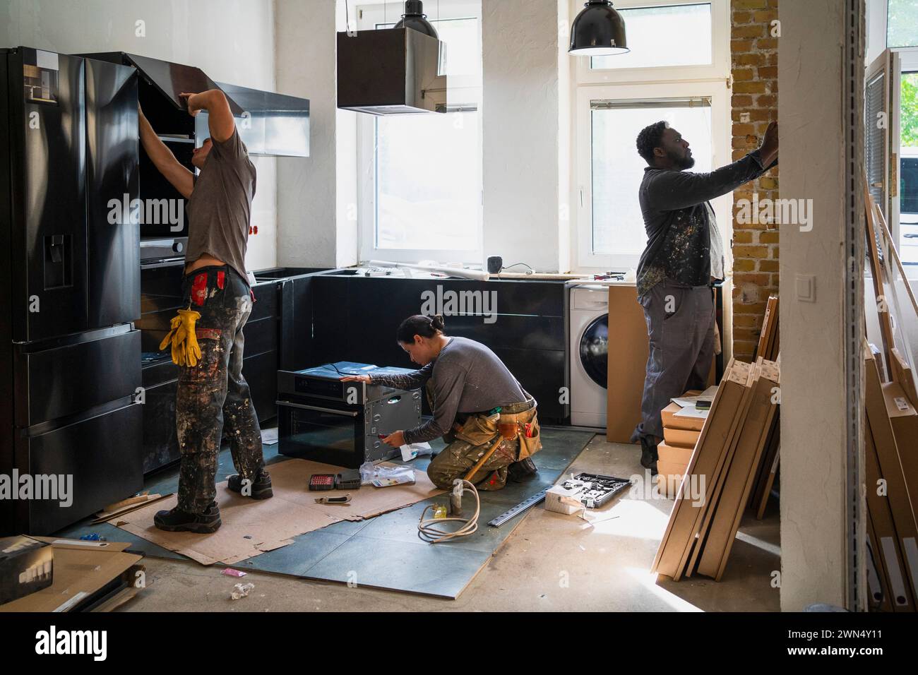 Verschiedene Zimmerleute, die in der Küche vor Ort arbeiten Stockfoto