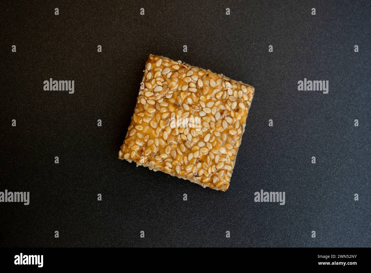 Bis Chikki auf schwarzgrauem Hintergrund. Till Chikki ist ein indisches Süßwarengericht, das mit Jaggery und Sesam zubereitet wird. Indisches Festival makar sankranti besonderes Süßes Stockfoto