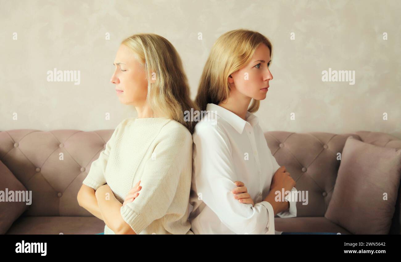 Verärgert beleidigte kaukasische Mutter mittleren Alters oder Schwester und Erwachsene Tochter zusammen auf der Couch zu Hause sitzen Stockfoto
