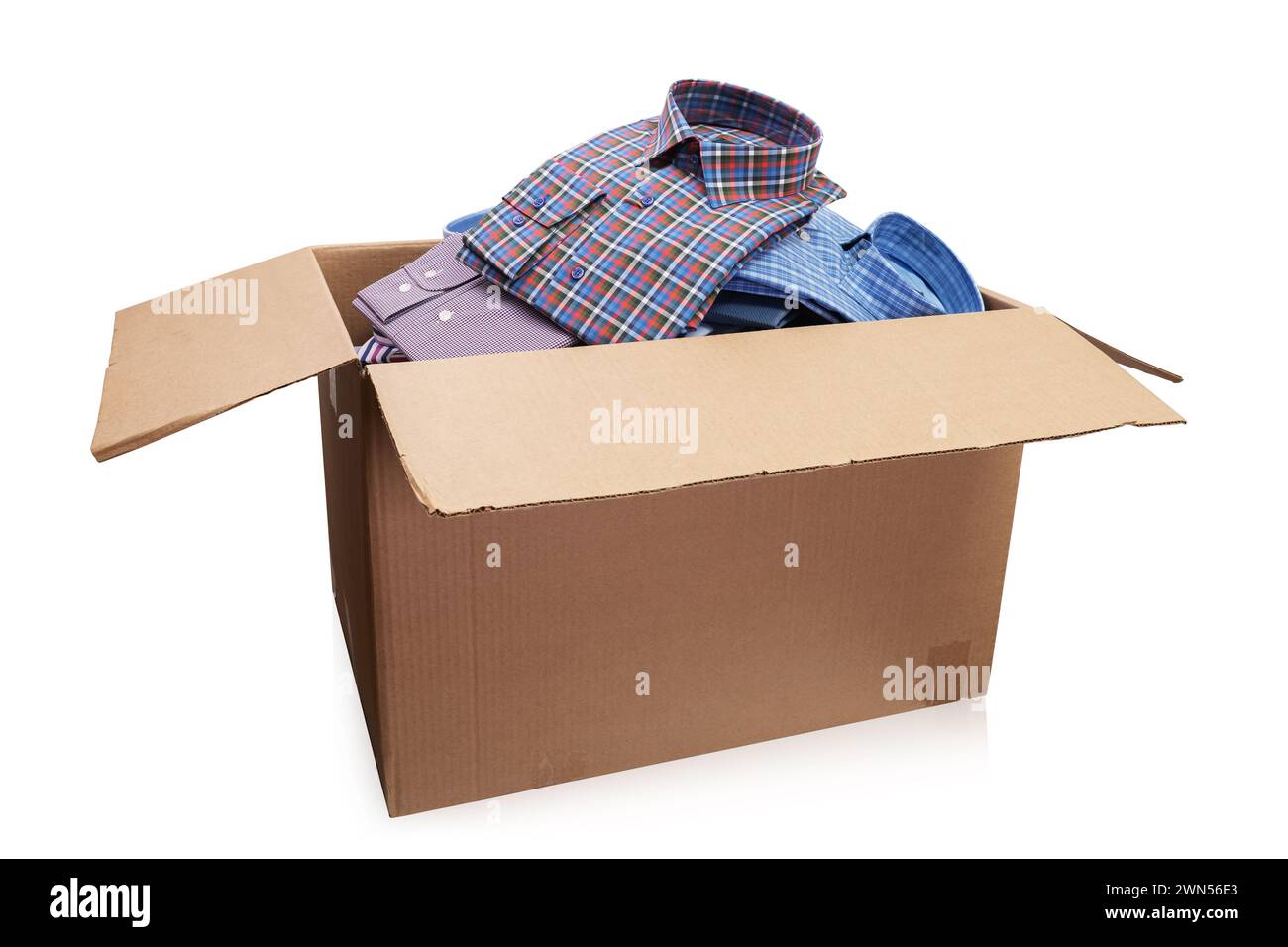 Offene Pappschachtel voller gefalteter Herrenhemden isoliert auf weißem Hintergrund Stockfoto