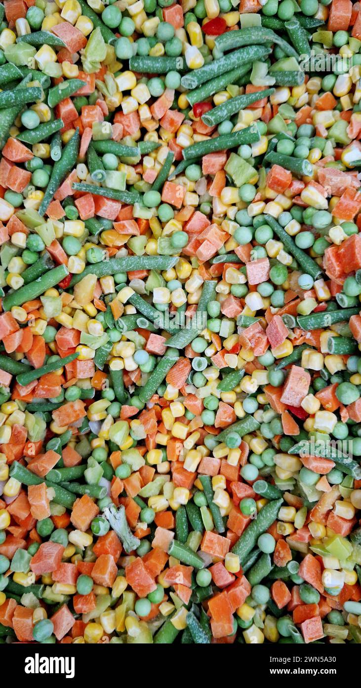 Gefrorenes Gemüse in einem Laden, Nahaufnahme. Gemischtes Gemüse wird im Kühlschrank im Supermarkt verkauft. Mischung aus Erbsen, Mais, grünen Bohnen, Paprika und Stockfoto