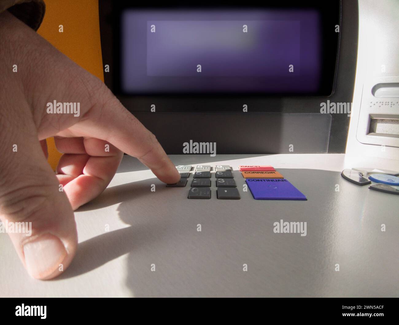 Reifer Mann, der die Kennwortnummer am Geldautomaten drückt. Zugängliche Tastatur Stockfoto