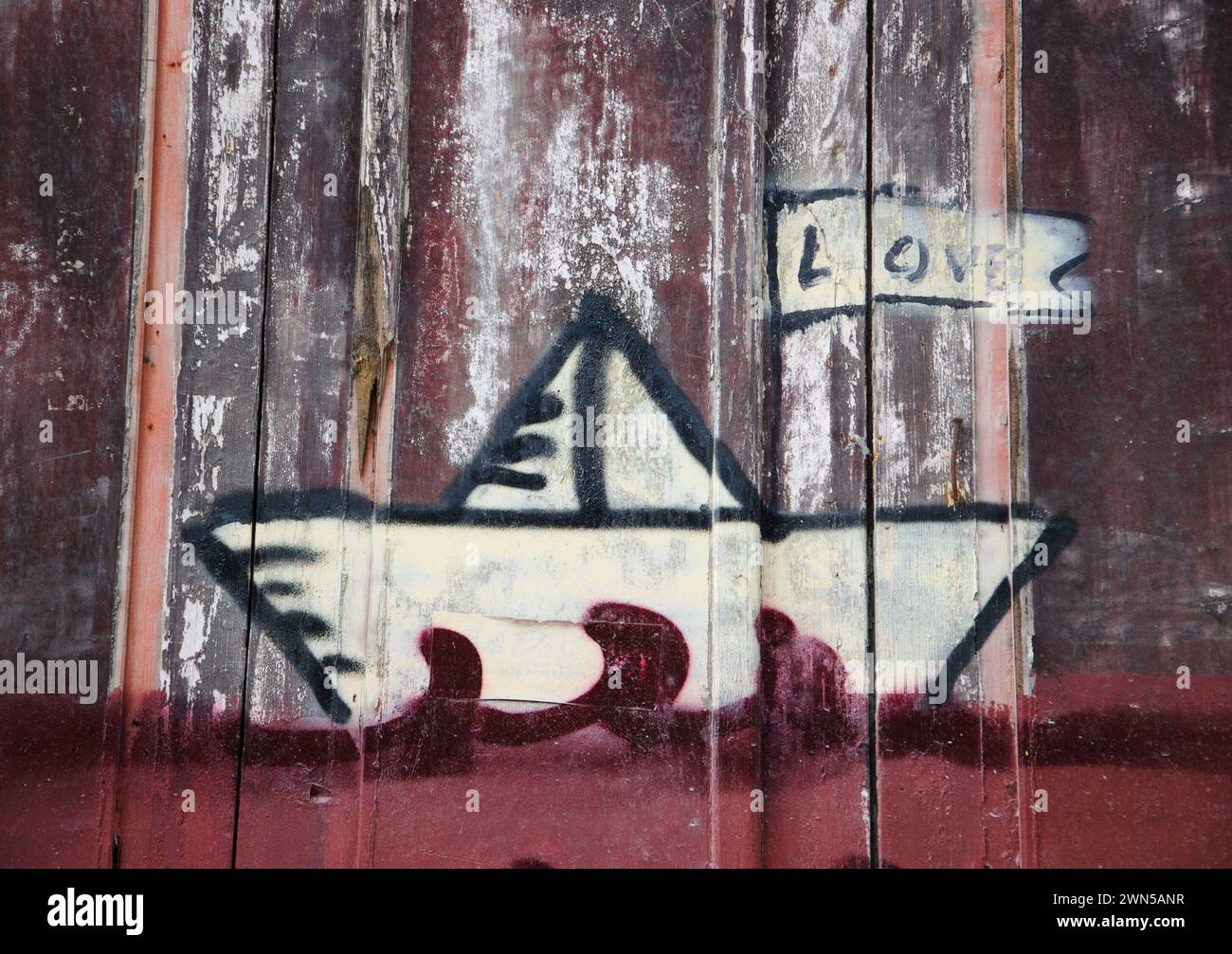 Porto, Portugal - 26. April 2015: Street Art. Love Ship Graffiti (Wort LIEBE auf der Flagge) an der Holztür des alten Hauses. Stockfoto