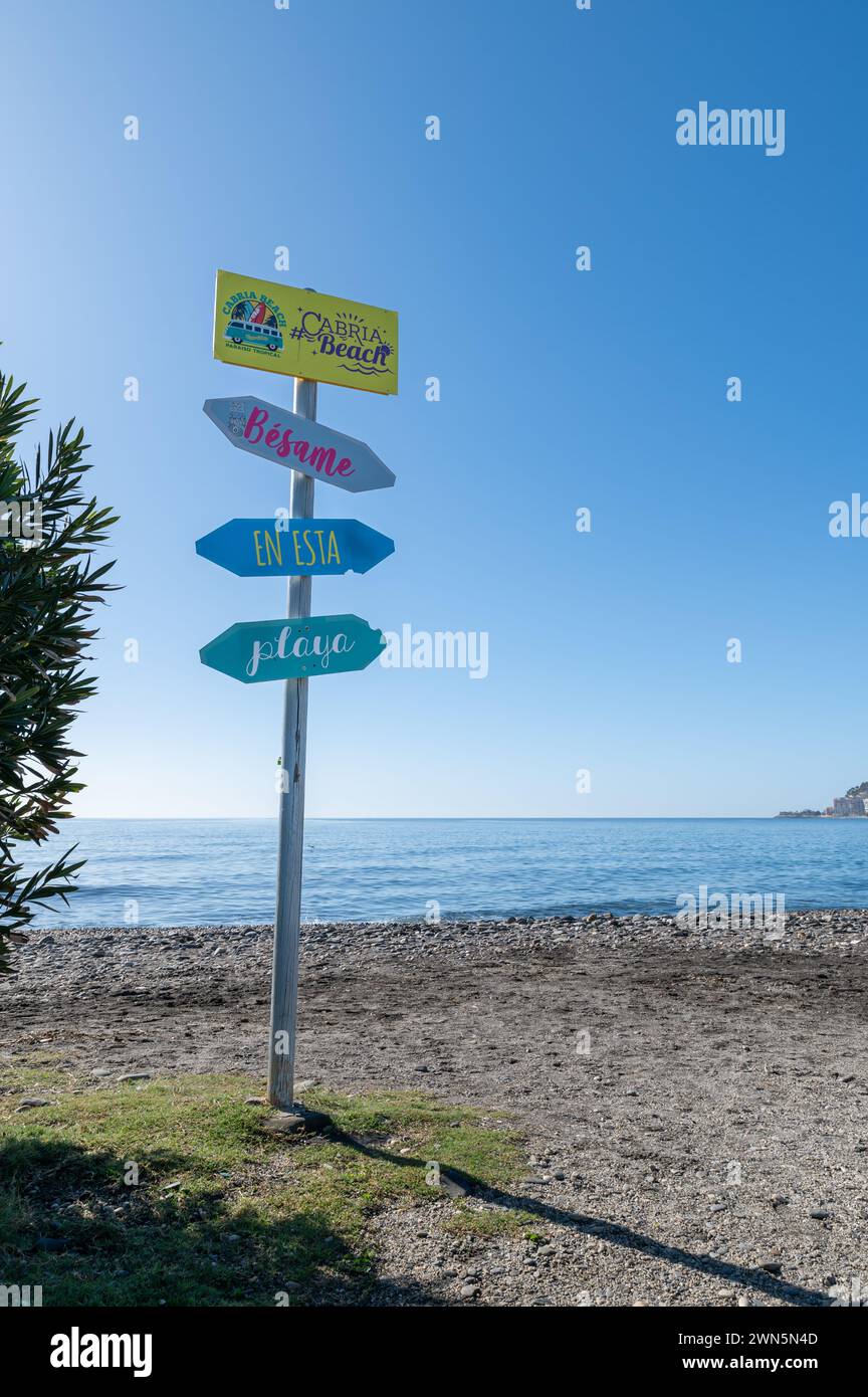 Almuñecar, Spanien; 22. Januar 2024: Schilder mit Pfeilen auf einem Pfosten am Strand von Cabria (Almuñecar, Spanien) mit der folgenden Botschaft: Küss mich an diesem Strand Stockfoto