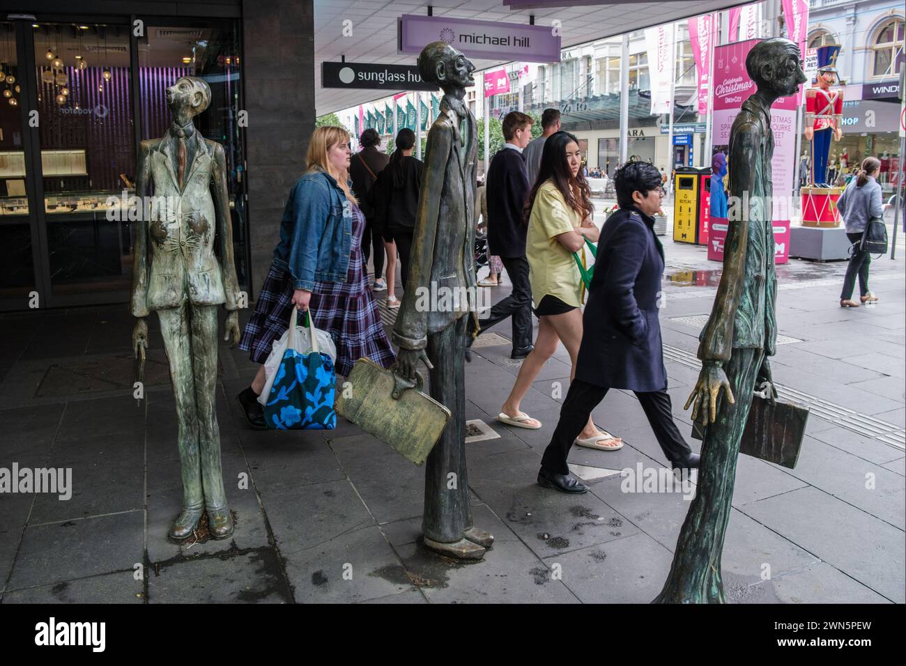 Die Skulptur „drei Geschäftsleute, die ihr eigenes Mittagessen mitbrachten“ an der Ecke Swanston Street und Bourke Street, Melbourne, Victoria, Australien Stockfoto