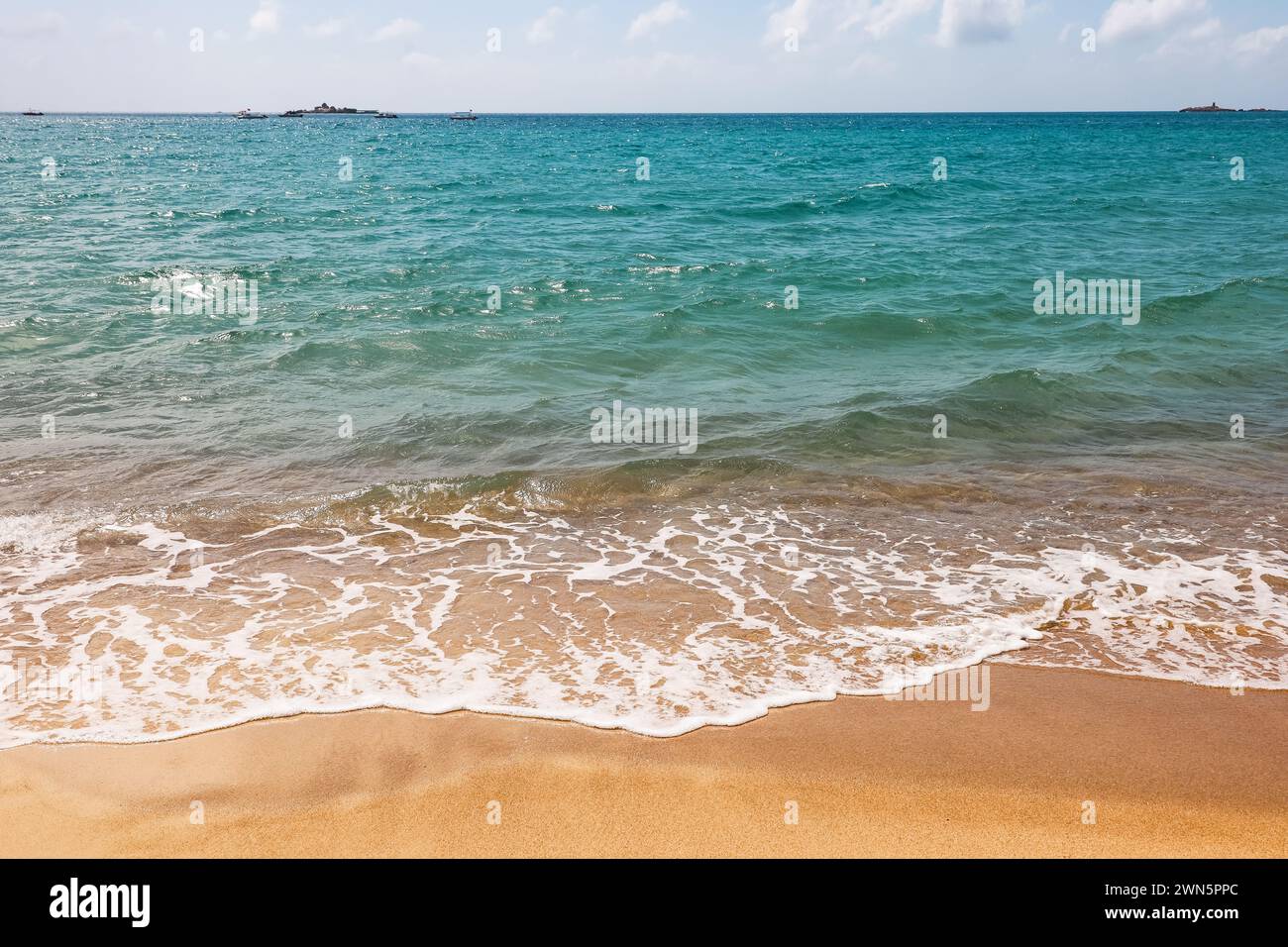 Leerer Strand mit Sand, Blick auf azurblaue Wellen. Hintergrund für einen Urlaub in einer paradiesischen Natur Stockfoto