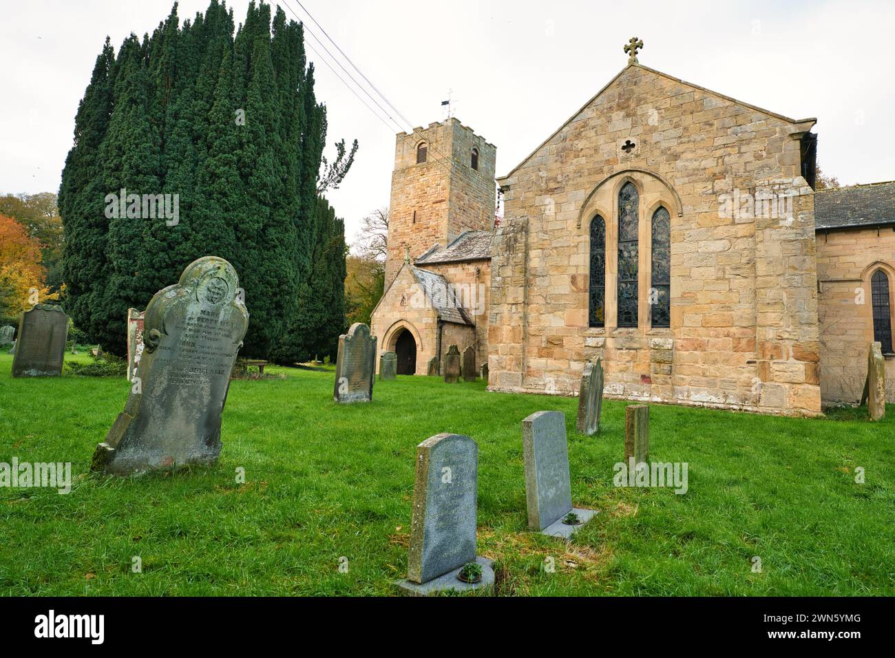 Angelsächsische Kirche mit den Buntglasfenstern und dem antiken Kreuz im Blick Stockfoto