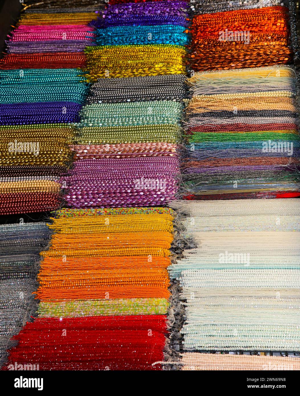 Stränge von sehr glänzenden farbigen Glasketten in vielen leuchtenden Farben zum Verkauf im Shop spezialisiert auf personalisierte Schmuckkreationen Stockfoto