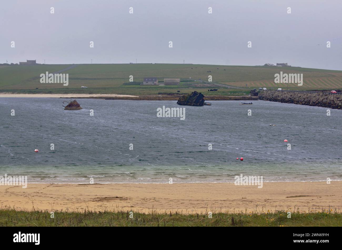 Blockschiffe aus dem 1. Weltkrieg und ein Churchill Barrieren aus dem 2. Weltkrieg wurden zum Schutz der Scapa Flow Naval Base in Orkney, Schottland, eingesetzt Stockfoto