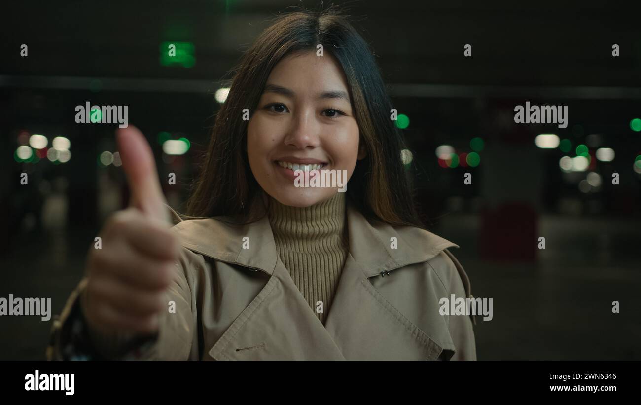 Glückliche asiatische Frau Mädchen zeigt Daumen nach oben Finger Geste beim Parken freudige chinesische koreanische Geschäftsfrau lächelt Autovermietung empfehlen gut Stockfoto