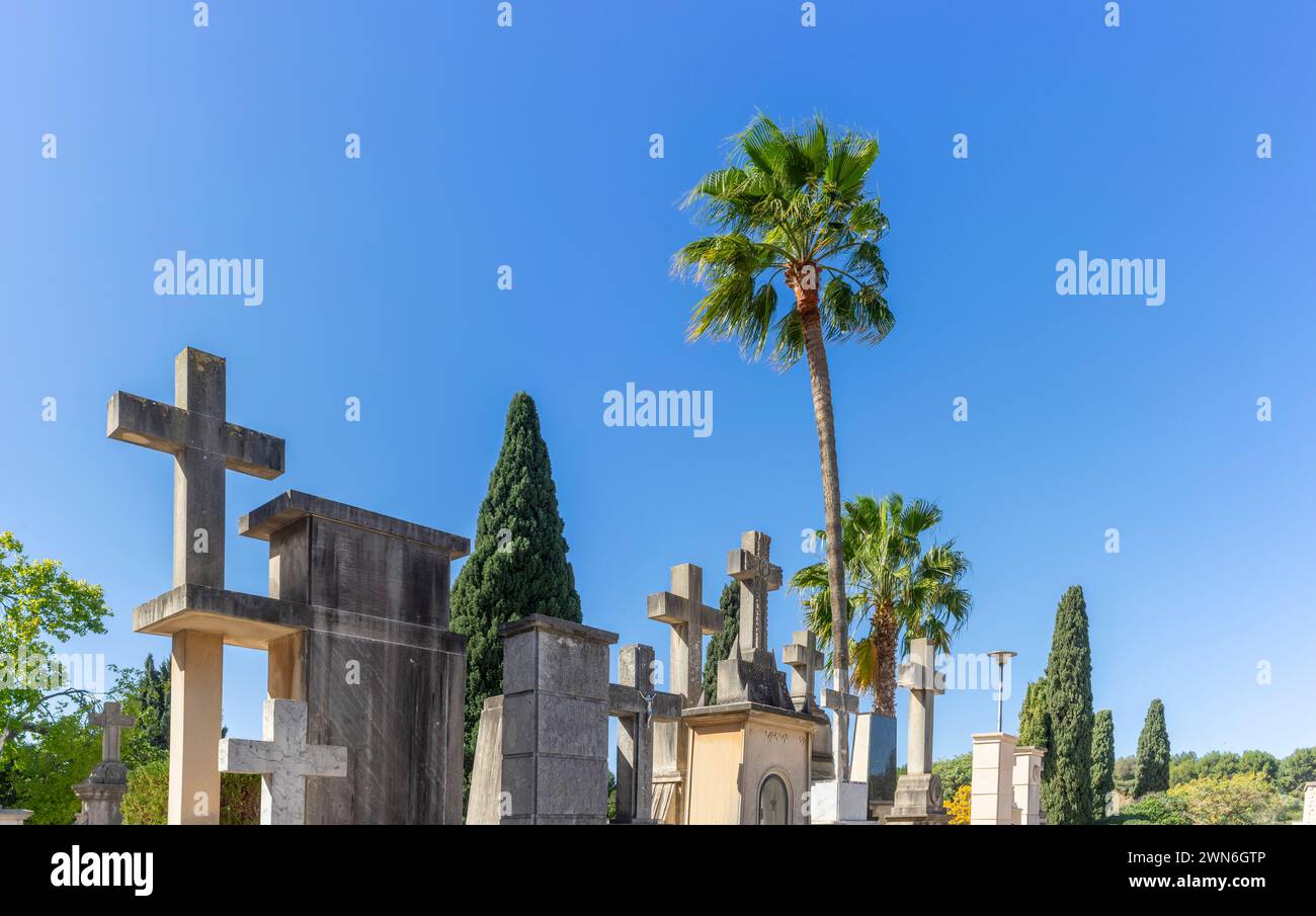 Ewige Ruhe: Überqueren Sie Denkmäler unter dem blauen Himmel auf dem ruhigen Friedhof Stockfoto